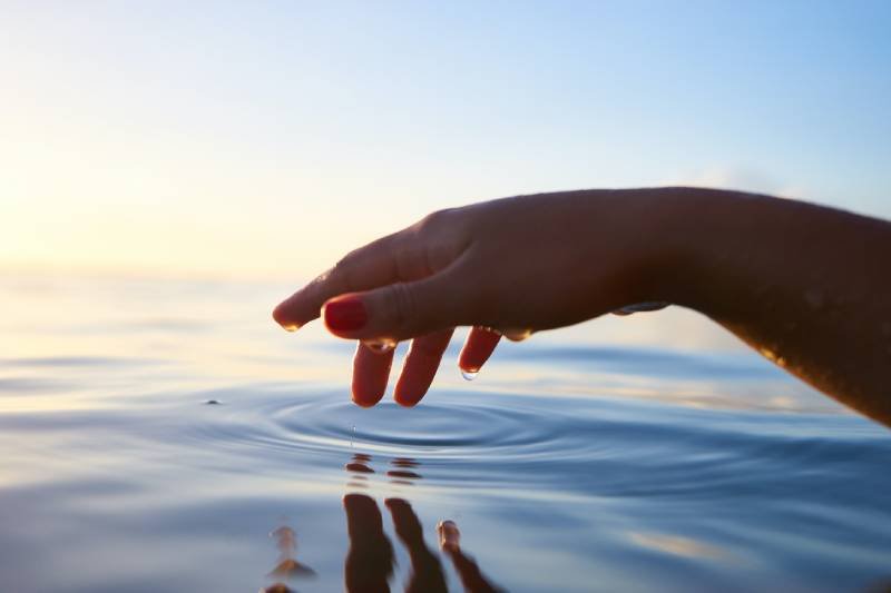 Photo of a person touching calm water