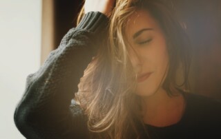 Image of a woman with beautiful brown long hair, wearing black sweater