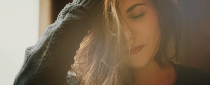 Image of a woman with beautiful brown long hair, wearing black sweater